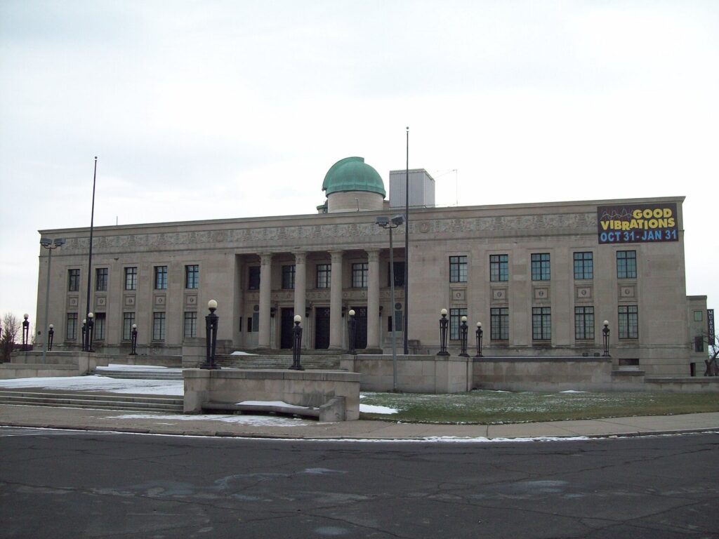 The limestone Buffalo Museum of Science with its green observatory dome on a snowy winter day