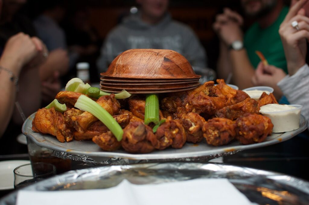 A platter of Buffalo chicken wings with celery and blue cheese on a table at the Anchor Bar, from this Buffalo NY food guide