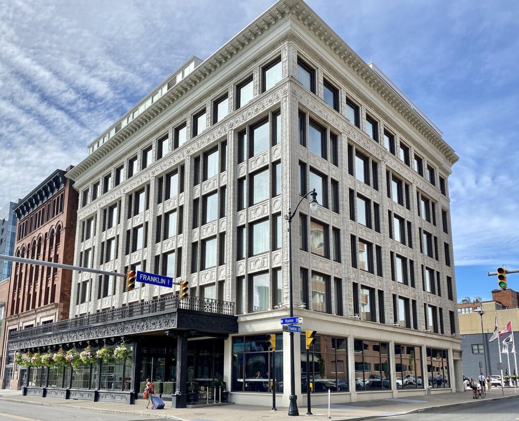 The restored white terracotta Curtiss Building, now the Curtiss Hotel, on a corner in downtown Buffalo