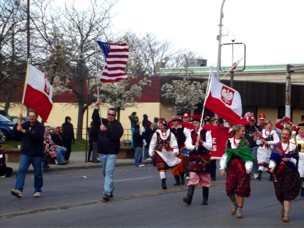 Marchers carrying Polish and American flags and dancers in traditional costume in the Dyngus Day parade in Buffalo