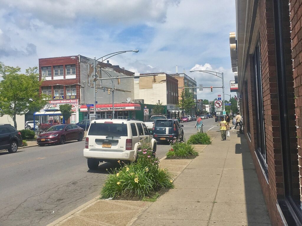 Grant Street on Buffalo's West Side, with shops, parked cars and trees on a sunny summer day