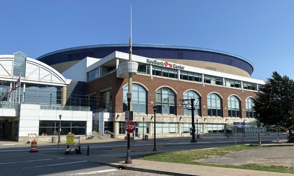 The KeyBank Center arena and its glass lobby seen from Main Street at Prime Street in downtown Buffalo on a sunny day
