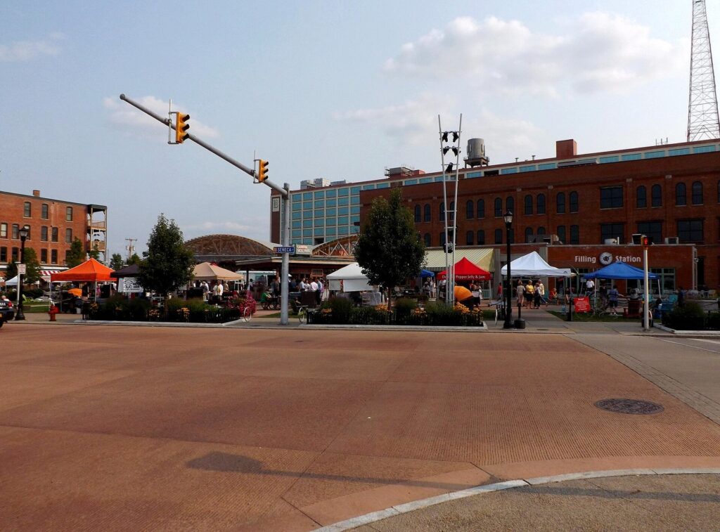 Market tents and visitors in Larkin Square in Buffalo's Larkinville, with brick warehouse buildings behind