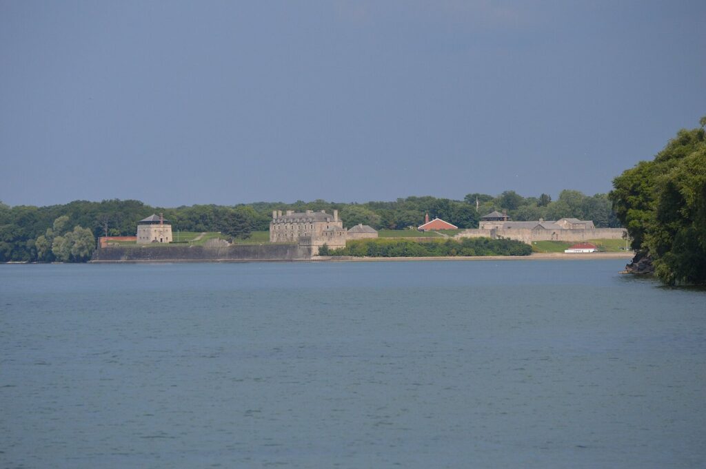 Old Fort Niagara's stone buildings and walls on the point where the Niagara River meets Lake Ontario, seen across the river from Canada