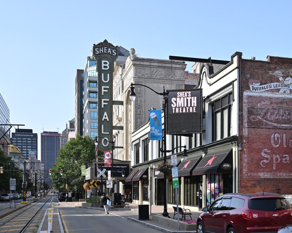 Main Street in Buffalo's Theater District with the vertical Shea's Buffalo sign, the Smith Theatre marquee and Metro Rail tracks