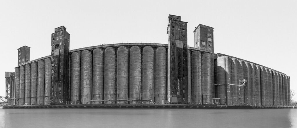 A black-and-white panorama of the massive concrete silos of Silo City on the Buffalo River